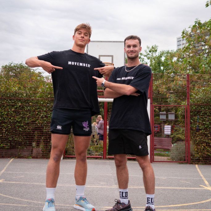 Two athletic young men, wearing Movember-branded shirts and looking to camera.