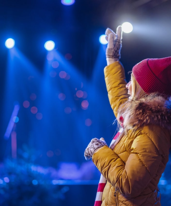 A young woman enjoys a concert after avoiding scams when she was buying a ticket.