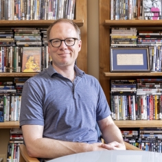 David Bamman in office setting with bookcase in background