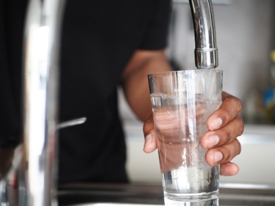 Drinking glass being filled with water from a faucet