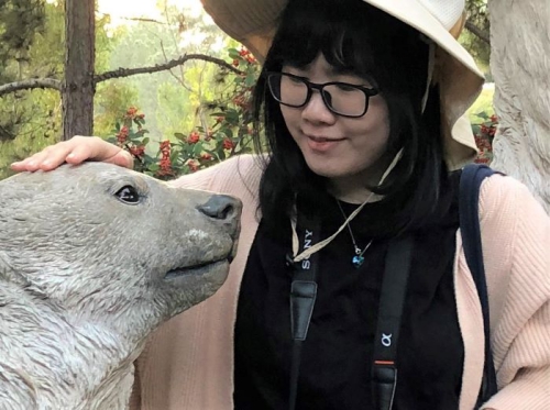 Photo of Anran Tu with a statue of a bear