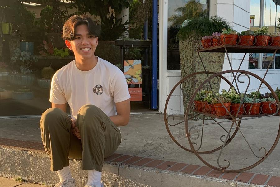 Student Coordinator, Izak, sitting on the curb