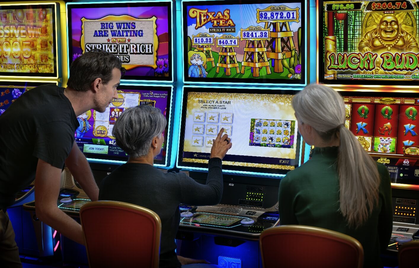 Three casino players at a slot machine