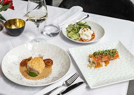 Plated dishes on table covered by white tablecloth