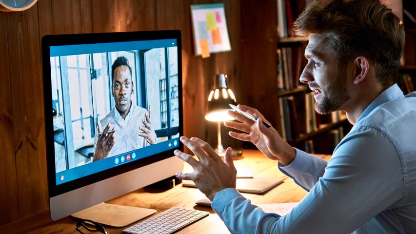 a conference call taking place at night on a computer where both male participants are engaged in discussion