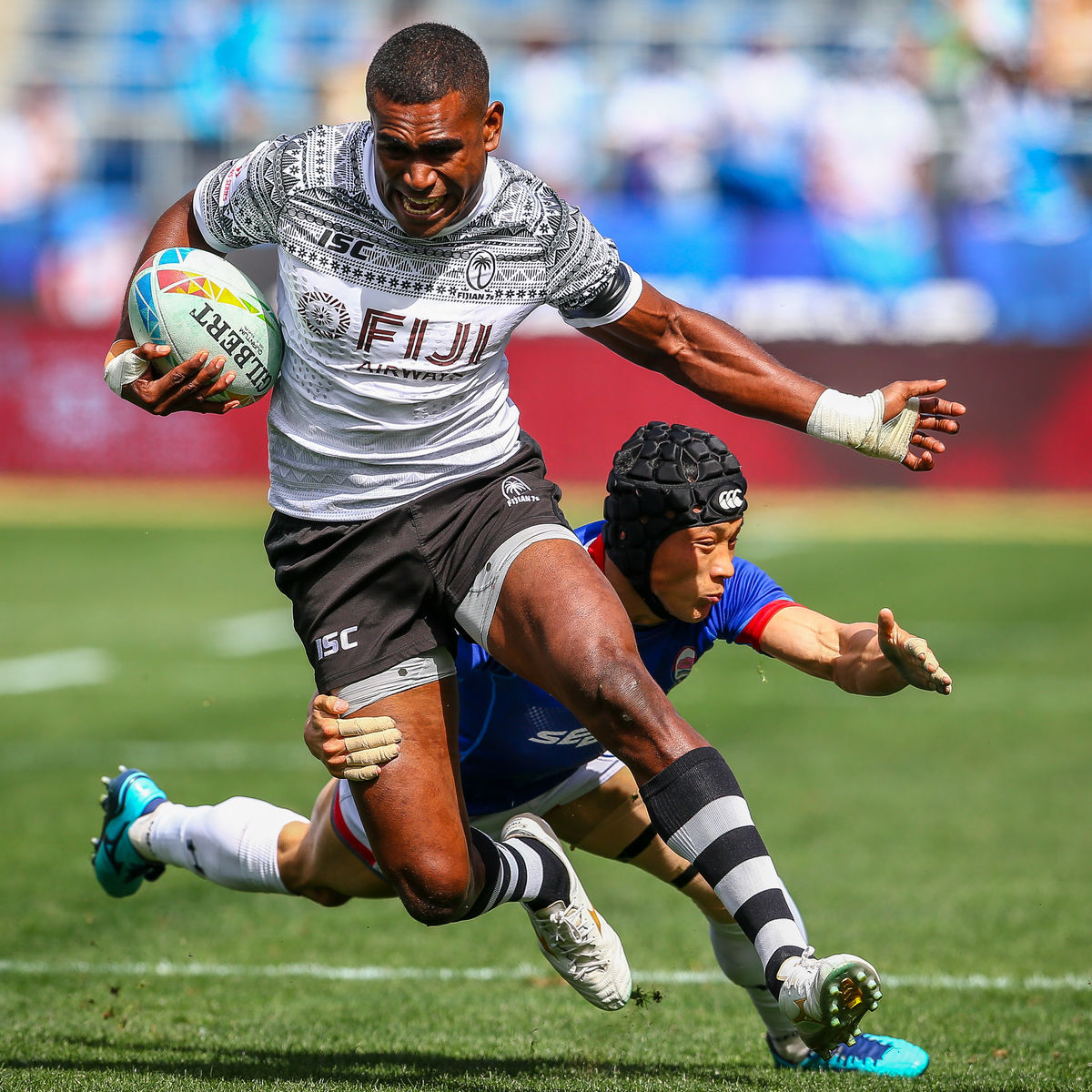 Rugby players trying to tackle an opponent