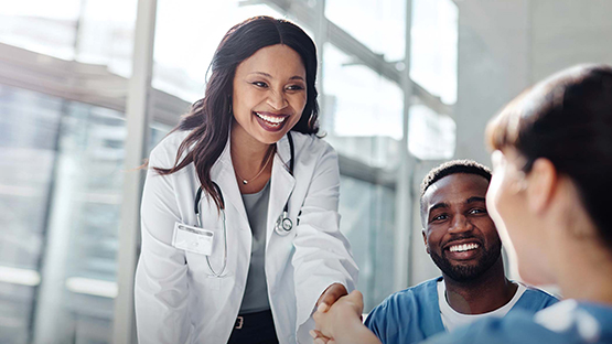 An AHN female physician shaking hands with a new member of the team.