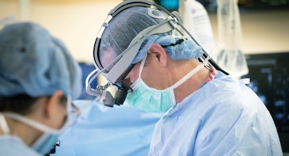 AHN surgeon wearing surgical mask, cap, and gown