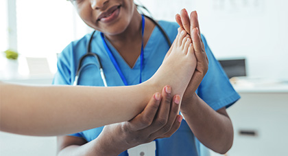 female doctor examining patient’s foot and ankle for possible injury