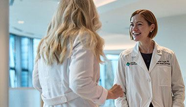 Two AHN cancer specialists posing in a photo with two patients.