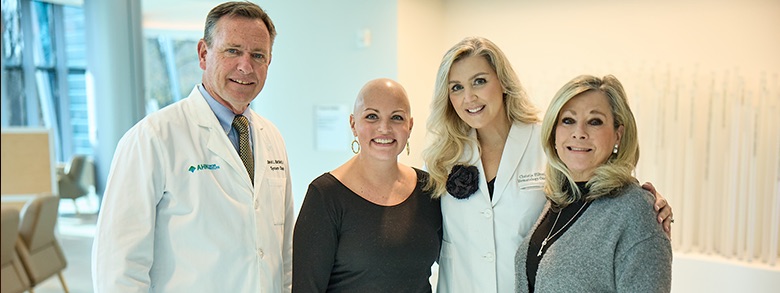 Group of doctors smiling with a patient in the lobby