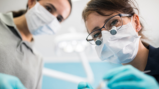 A dentist and a dental hygienist looking into the camera.