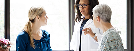 A doctor talking to a patient and their daughter.