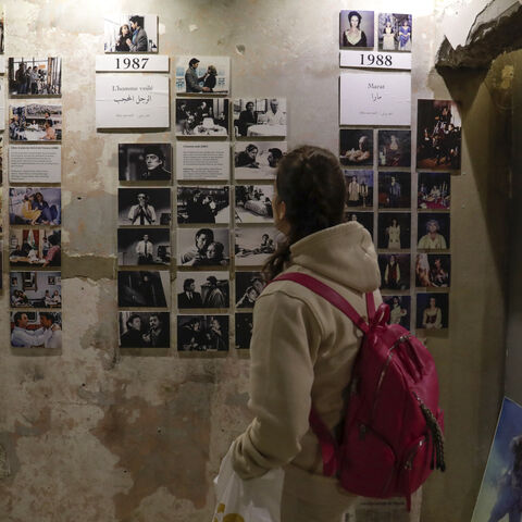 A visitor looks at portraits of late Franco-Lebanese film director Maroun Baghdadi and pictures from his movies at the venue of an exhibition dedicated to his memory in Beirut on December 12, 2023, as Lebanon commemorates the 30th annivesary of his death in an accident at the age of 43. (Photo by ANWAR AMRO / AFP) (Photo by ANWAR AMRO/AFP via Getty Images)