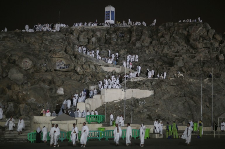 Pilgrims dressed in white shown on the stairs of the hill