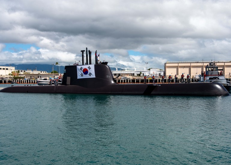 The Republic of Korea Navy submarine Lee Beom-seok sailing into Hawaii. It's black and has a South Korean flag on the side of its tower.