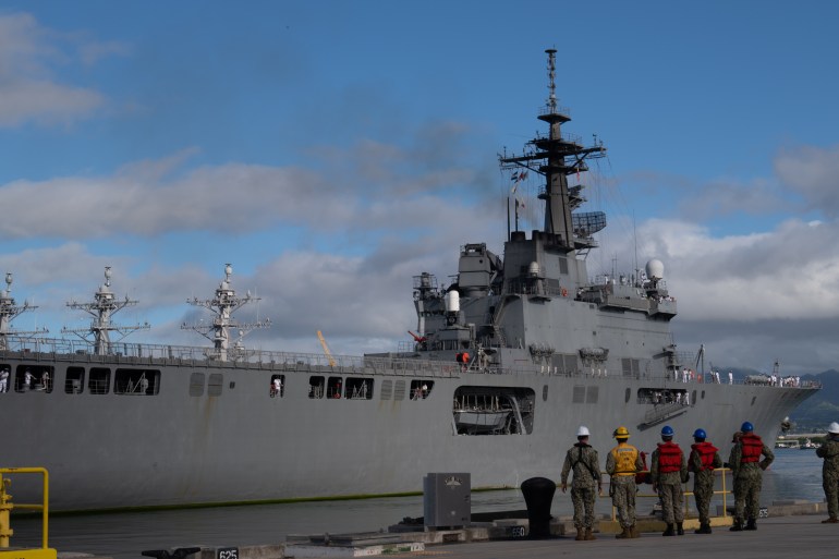 Sailors on the quay as they prepare to moor the Japan Maritime Self-Defense Force Ōsumi-class amphibious transport dock ship JS Kunisaki