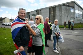 Locals wait for the arrival of Nigel Farage, leader of the right-wing Reform UK party, in Merthyr Tydfil, south Wales [Justin Tallis/AFP]