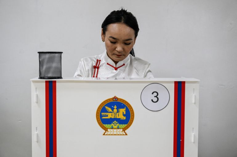 A woman voting in the Mongolia election. She is in the voting booth, making her choice.