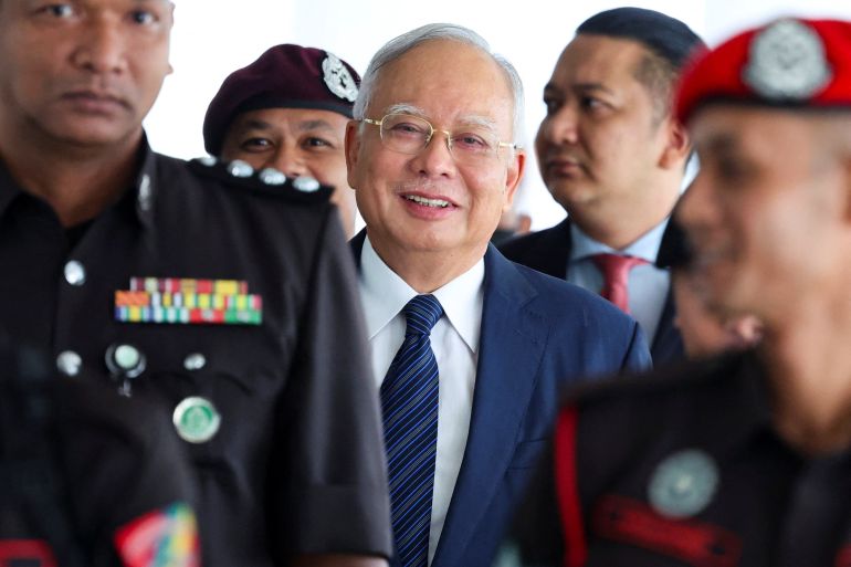 Prison officers escort former Malaysian Prime Minister Najib Razak, as the jailed politician leaves the court during a break in proceedings, in Kuala Lumpur, Malaysia, April 4, 2024.