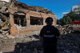 A police officer inspects the site where a residential building was heavily damaged by a Russian air strike, amid Russia&#039;s attack on Ukraine, in Kharkiv, Ukraine, on July 3, 2024 [Vyacheslav Madiyevskyy/Reuters]