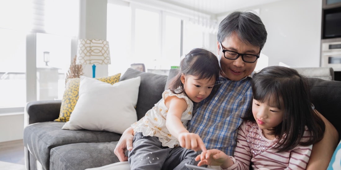 Grandfather sitting and holding two young children