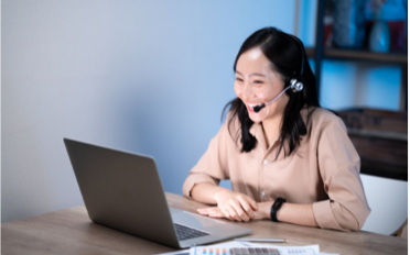 woman with headset while on their laptop