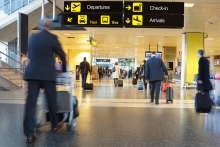 International airport terminal with people walking with their luggage.