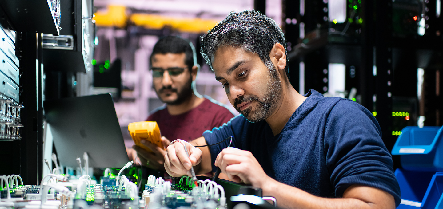 Two Apple engineers work on iPhone components in a lab