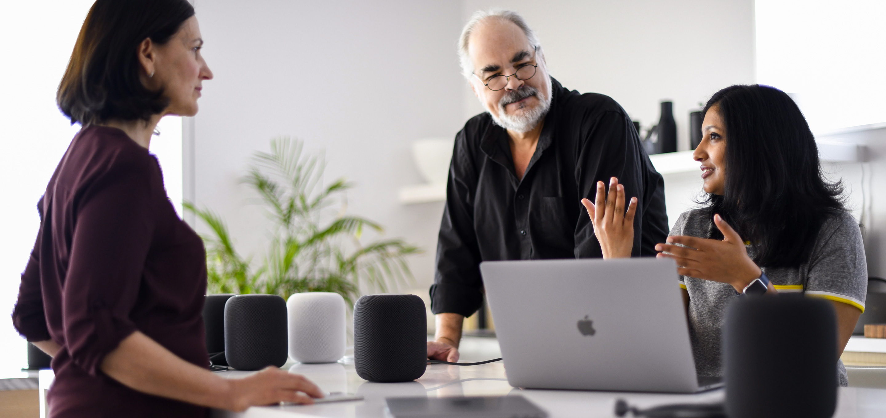 Funcionários das equipes de aprendizado de máquina e de inteligência artificial da Apple conversam em um escritório.