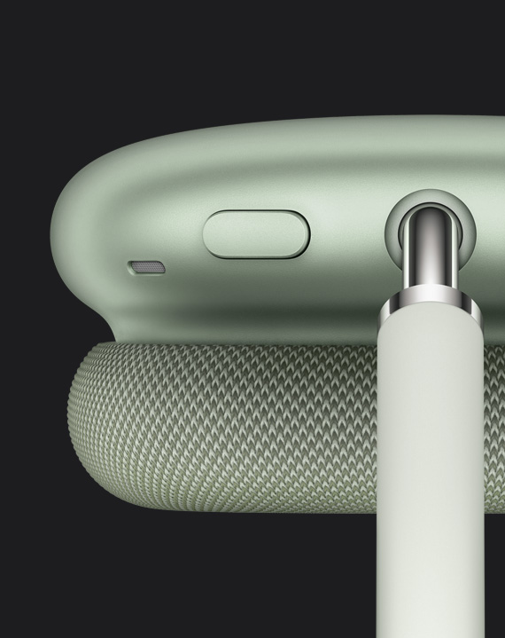 Gros plan sur le bouton de contrôle du bruit situé sur le dessus de l’écouteur, à côté de la tige qui relie l’écouteur à l’arceau, AirPods Max verts.