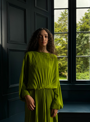 Foto tomada en 28 mm de una mujer con un vestido verde