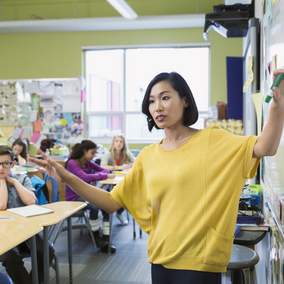 Teacher instructing a group of students inside a classroom