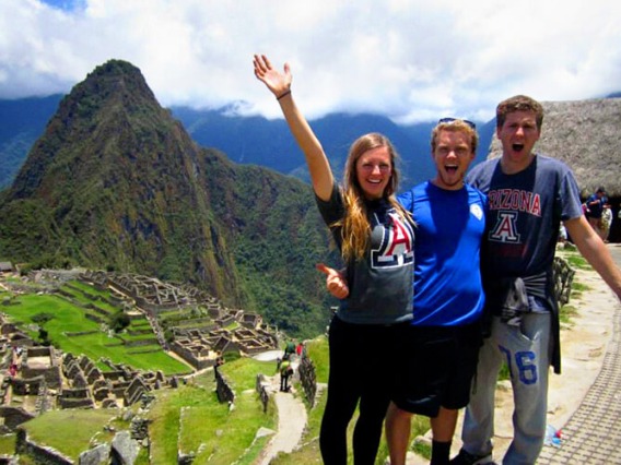 Students atop a hill at Machu Picchu, Peru on a cloudy day