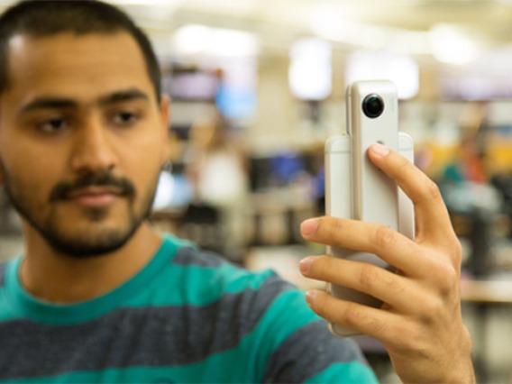 Student using a handheld device from the Library Borrow Technology Program