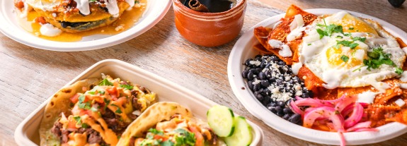 Top view of food dishes spread on a wood table