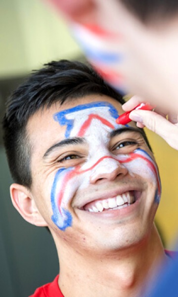 UArizona student putting face paint on for a game