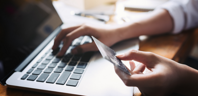 hands holding credit card over laptop