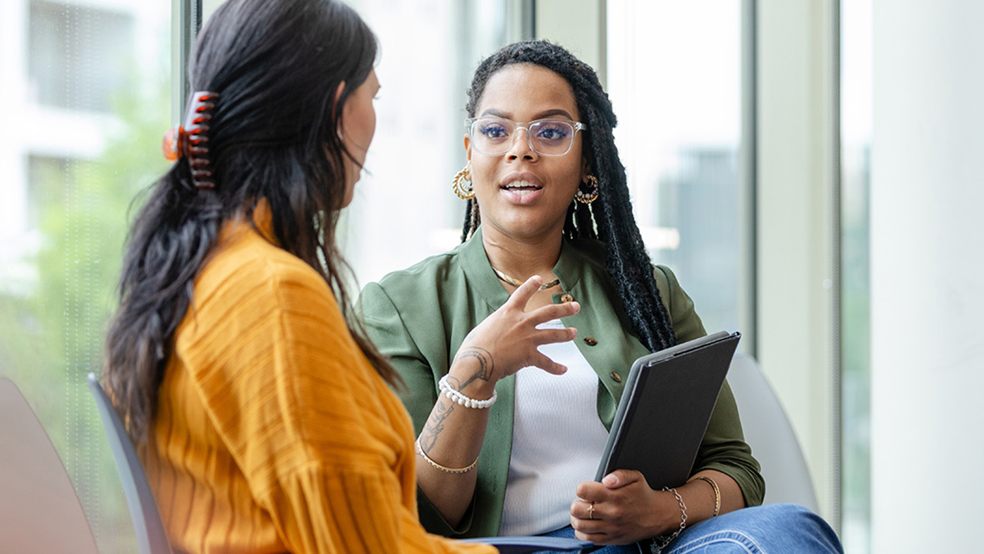 Two women in an interior environment having a conversation