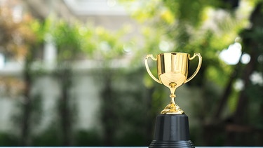 Ein goldener Pokal. | Bild: stock.adobe.com/Witthaya