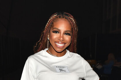 Candiace Dillard poses for a photo while wearing a white dress.