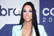 Rachel Fuda smiling in front of a step and repeat at BravoCon 2023.