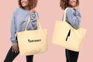 A model holding a large tote back with Top Chef written on it and also a knife illustration on it.