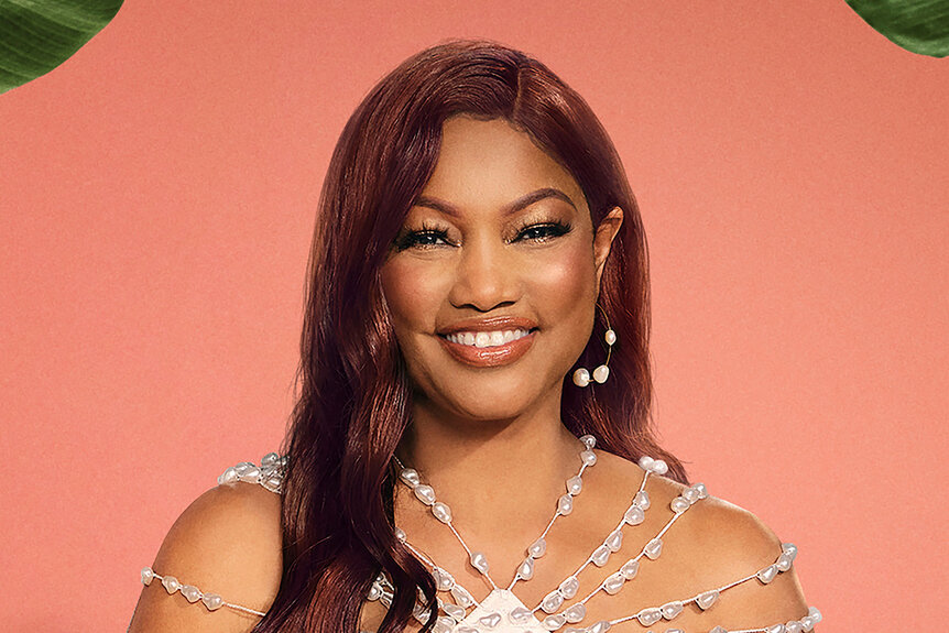 Garcelle Beauvais wearing a white dress with white stone beading.