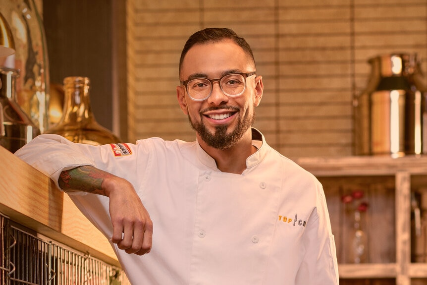 Danny Garcia wearing a chef's uniform in a kitchen pantry