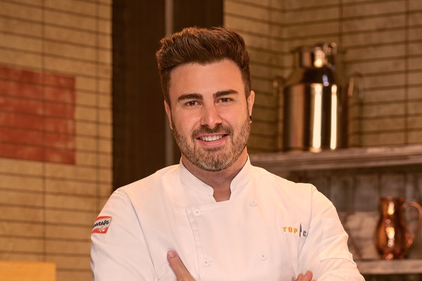 Kevin Dandrea wearing a chef's uniform in a kitchen pantry