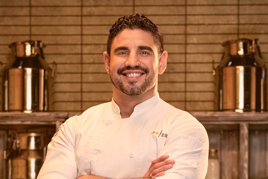 Manuel Barella wearing a chef's uniform in a kitchen pantry