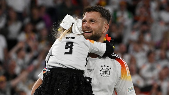 Niclas Füllkrug (Deutschland) feiert mit seiner kleinen Tochter auf dem Spielfeld