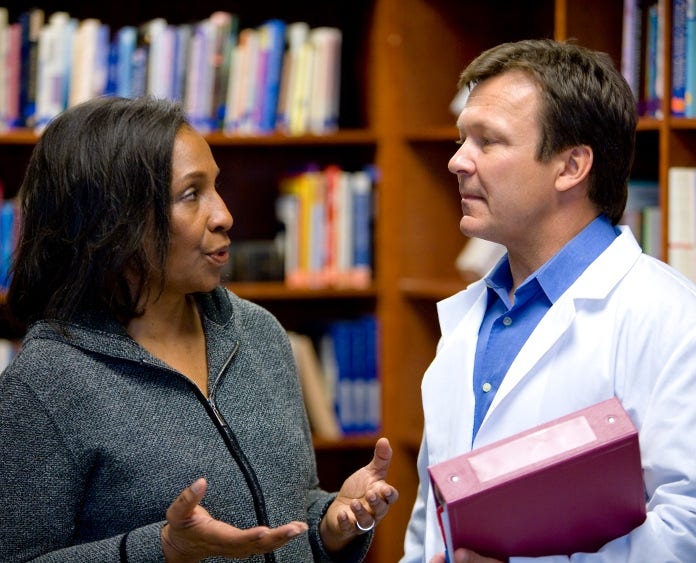 Woman speaking with doctor in resource area