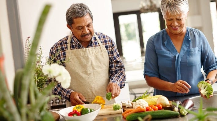 Man and woman chopping vegetables